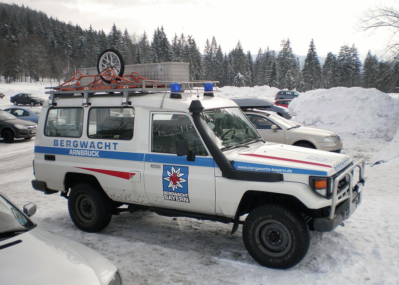 A Toyota Land Cruiser 70 Series mountain-rescue vehicle with roof-mounted equipment in snowy Bavaria